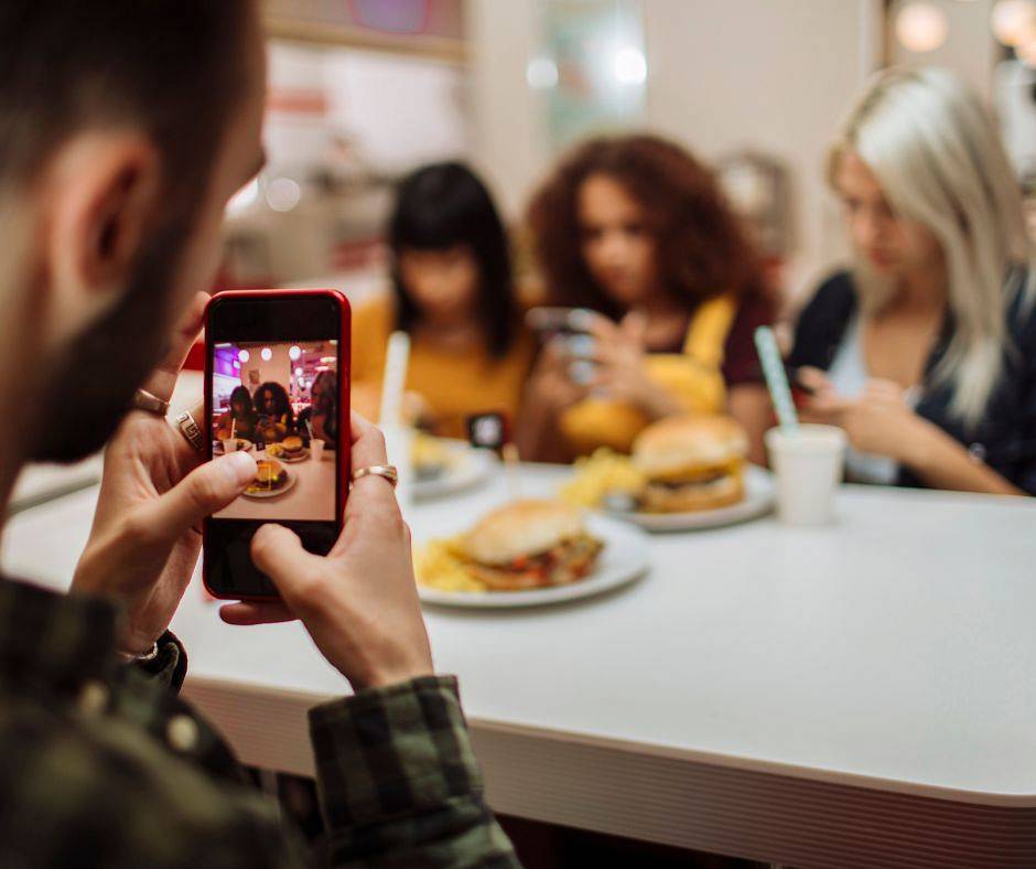 Group of friends are using social media as they are during the dinner together